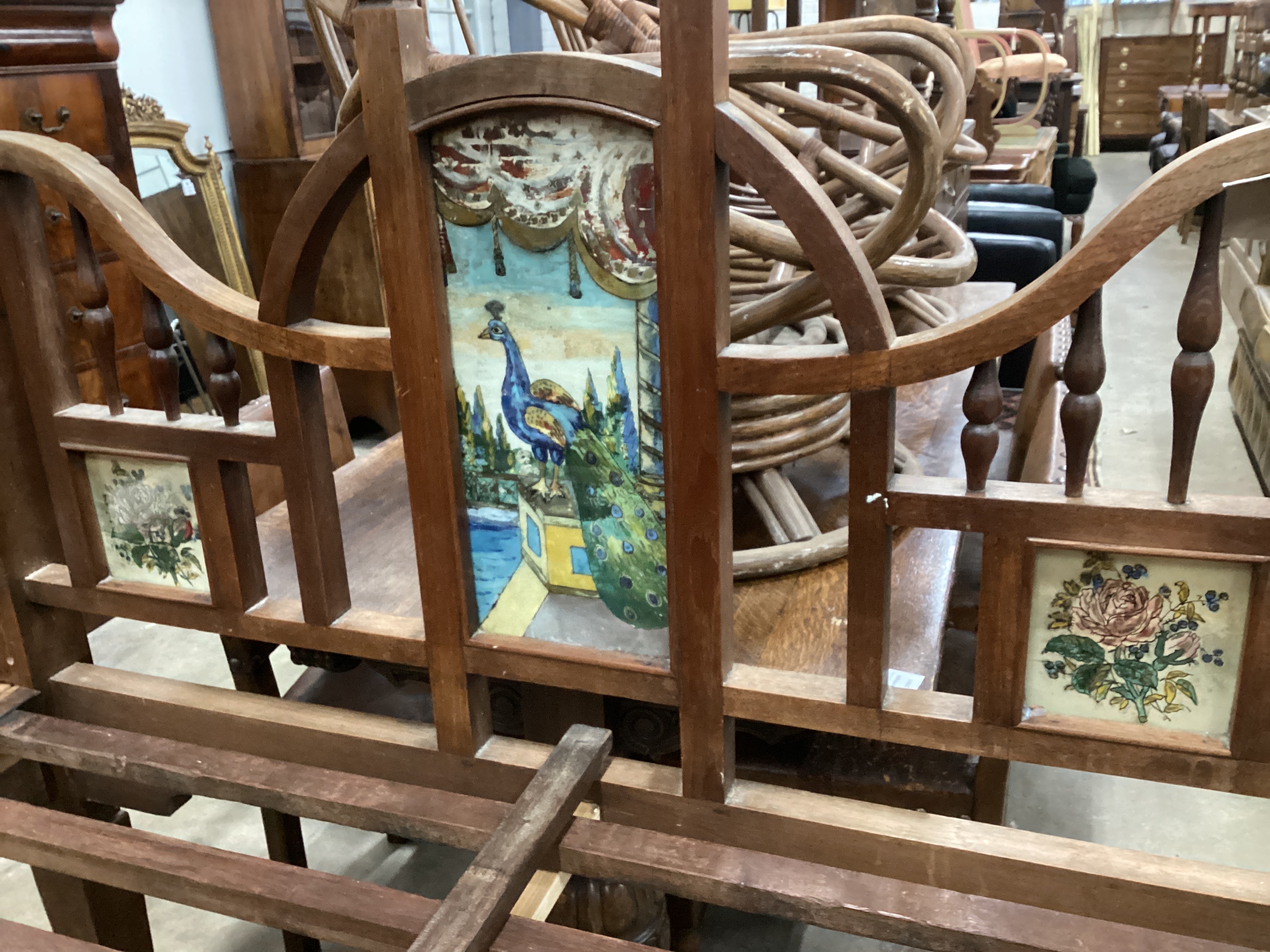 A 19th century Zanzibar hardwood bedframe inset reverse painted glass panels of peacocks and vases of flowers, length 210cm, width 140cm, height 215cm